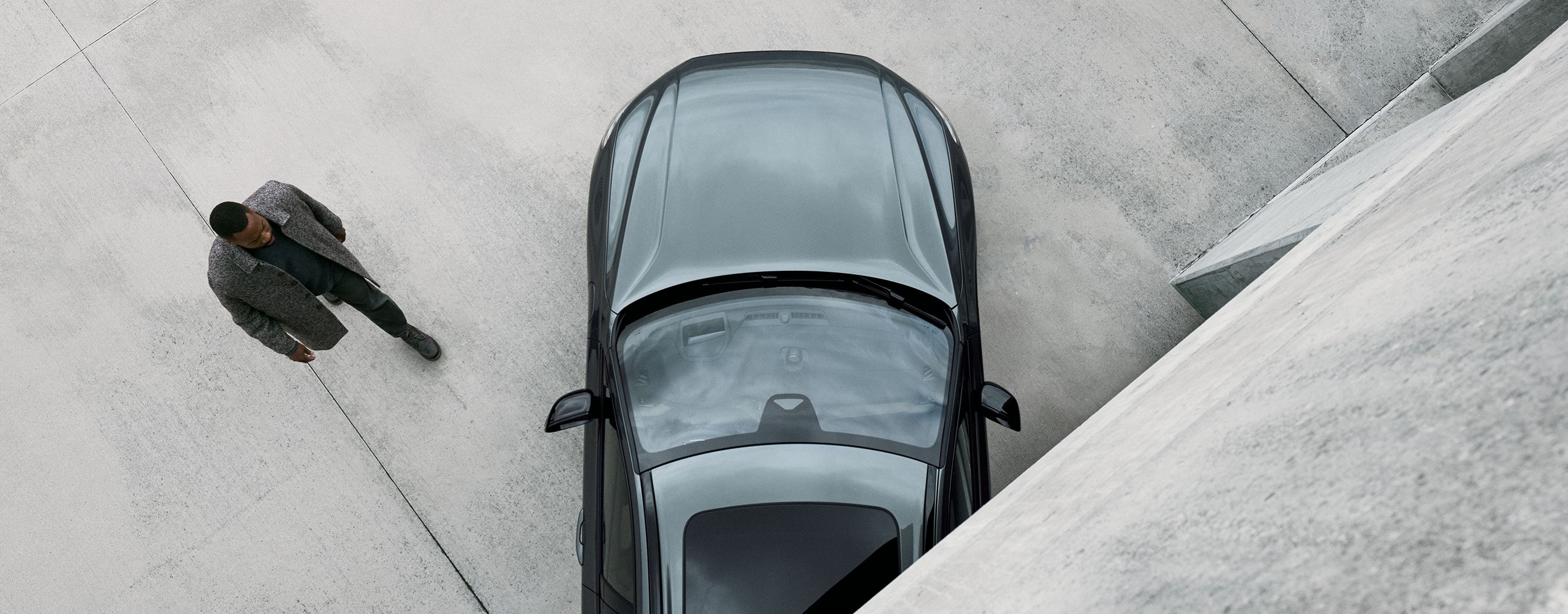 Mann geht auf Treppe von einem Volvo S90 weg